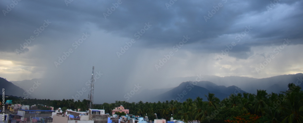 Rain shower falling from dark cumulus clouds