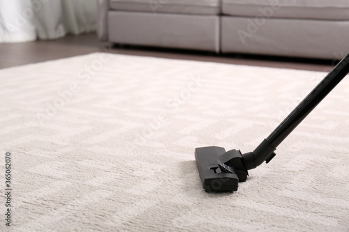 Hoovering floor with modern vacuum cleaner, closeup. Space for text