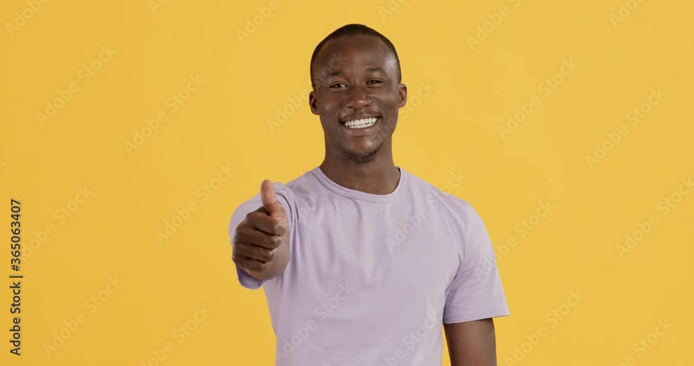 Happy black guy gesturing thumb up and widely smiling Happy black guy gesturing thumb up and widely smiling