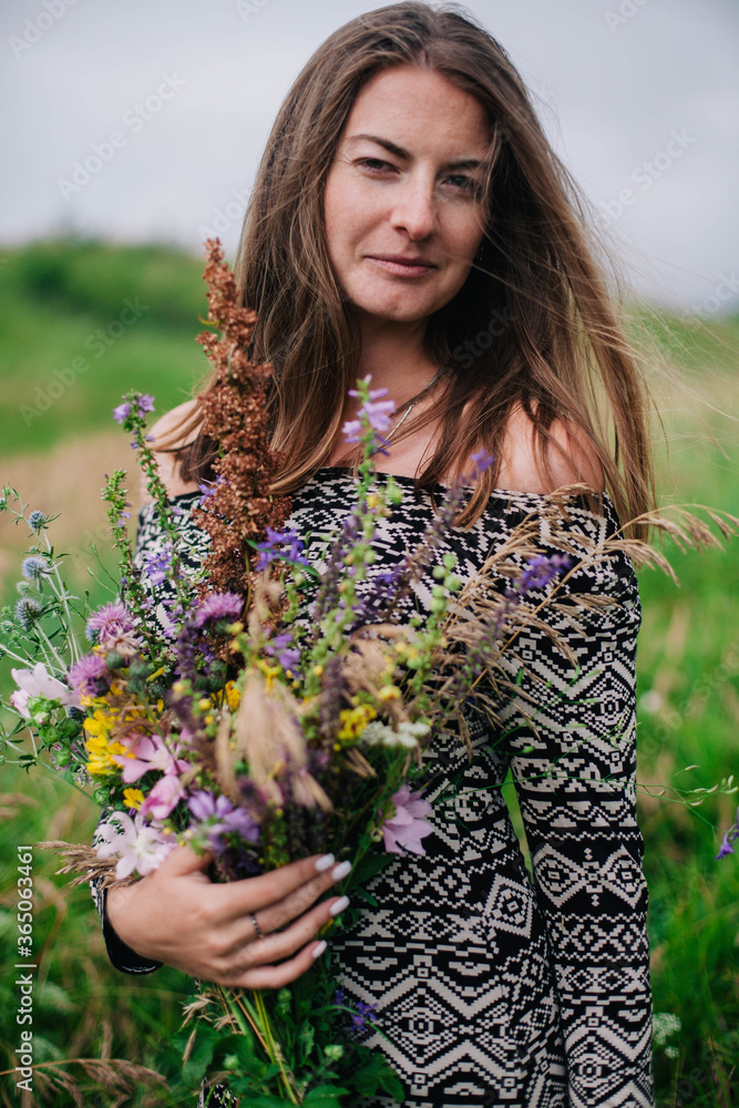 Beautiful, slender girl in a meadow dress with wildflowers Beautiful, slender girl in a meadow dress with wildflowers