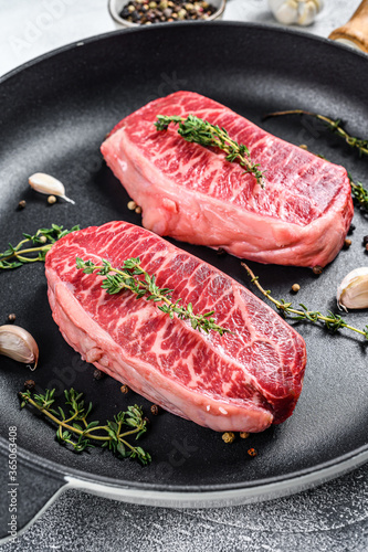Raw marbled beef steak, top blade meat steak. Gray background. Top view