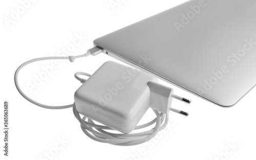 Laptop and charger on white background. Modern technology