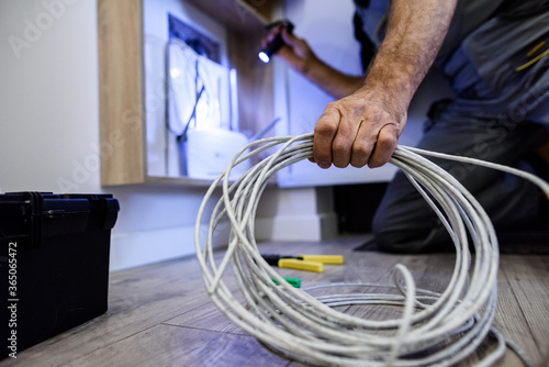 Obraz na plátně Close up shot of hand of aged electrician, repairman in uniform working, fixing,