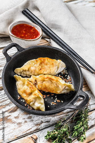 Fried dumplings in a pan, Chinese food cooking.  White background. Top view