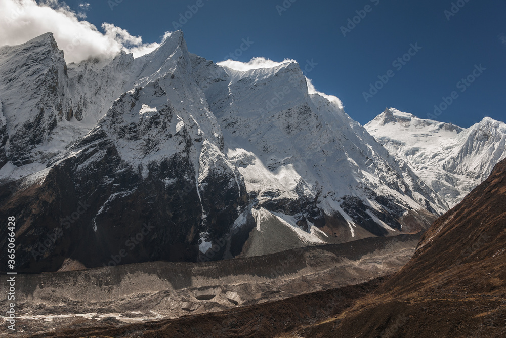 Obraz premium Manaslu summit rises above the far south end of Syancha glacier valley, as seen from Samdo village to Larkya Phedi camp on Manaslu Circuit trek, Manaslu Himal range, Gorkha district, Nepal Himalayas.