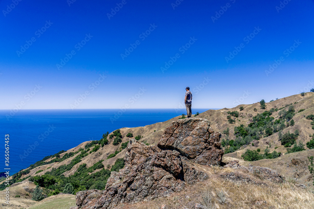 Hiker in the Mountains with Ocean background