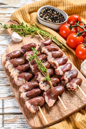 Raw shish kebab with chicken hearts on a wooden skewer. White background. Top view