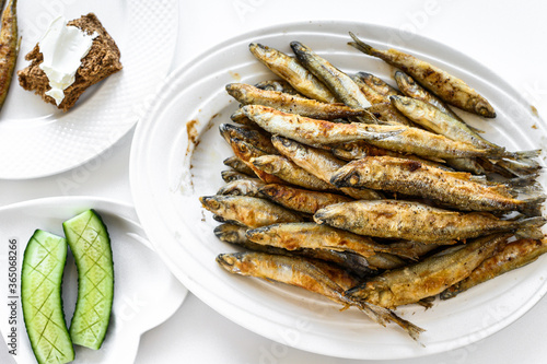 Appetizer of fried sprat and vegetables. White background. Top view