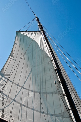 Yacht sail in focus. Yacht equipment and tackle close-up. Deck of the sailing yacht. Yacht sailing to the shore on a sunny day. Yachting in the sea. Yachting sport. Ocean regatta on sailing yachts.
