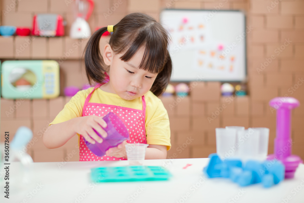toddler girl making sweet gems for homeschooling in the kitchen build by cardboard toddler girl making sweet gems for homeschooling in the kitchen build by cardboard