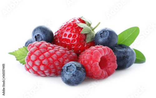 Pile of different ripe tasty berries with green leaves isolated on white