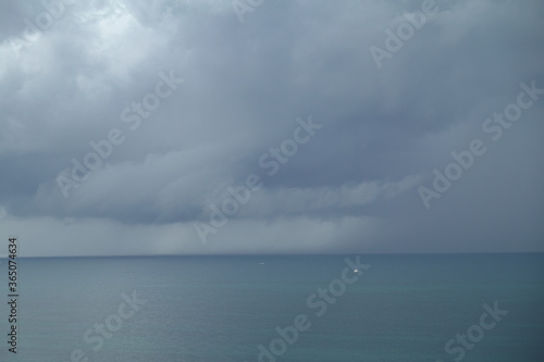 A storm over the colorful Atlantic Ocean with dark clouds.