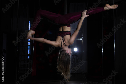 Young beautiful girl air gymnastics coach, workout ring, stretching, poledance, dance studio, movement