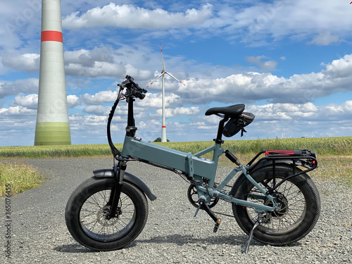 Modern electric Fatbike with wind turbine in the background photo