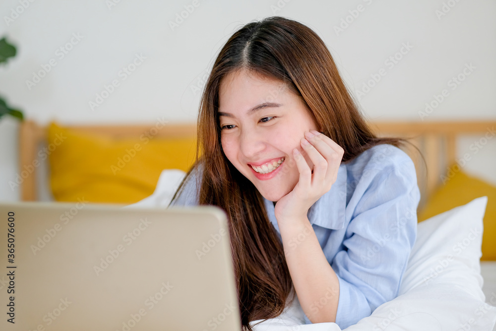 Beautiful woman use laptop on bed for working and she look happy in bedroom. Concept of happiness work from home help to get better result in business. Beautiful woman use laptop on bed for working and she look happy in bedroom. Concept of happiness work from home help to get better result in business.