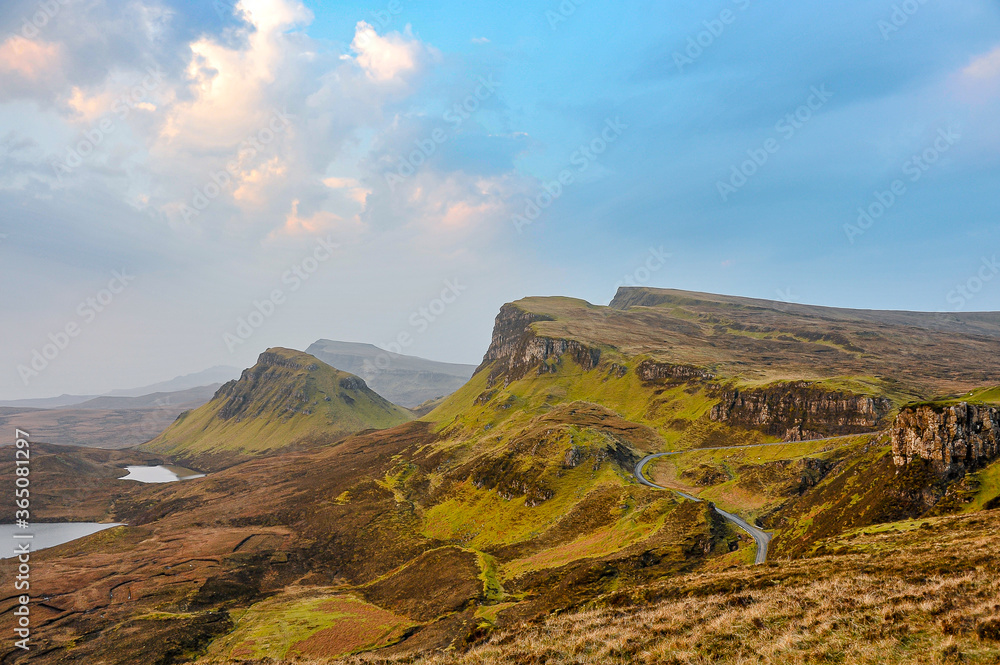 Looking south, cliffs of the Quiraing in the late morning with blue skies and clouds.  In the month of April on the Isle of Skye, Scotland.