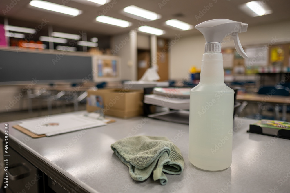Spray bottle of sanitizer sitting on teacher's desk in classroom for Covid 19 Spray bottle of sanitizer sitting on teacher's desk in classroom for Covid 19