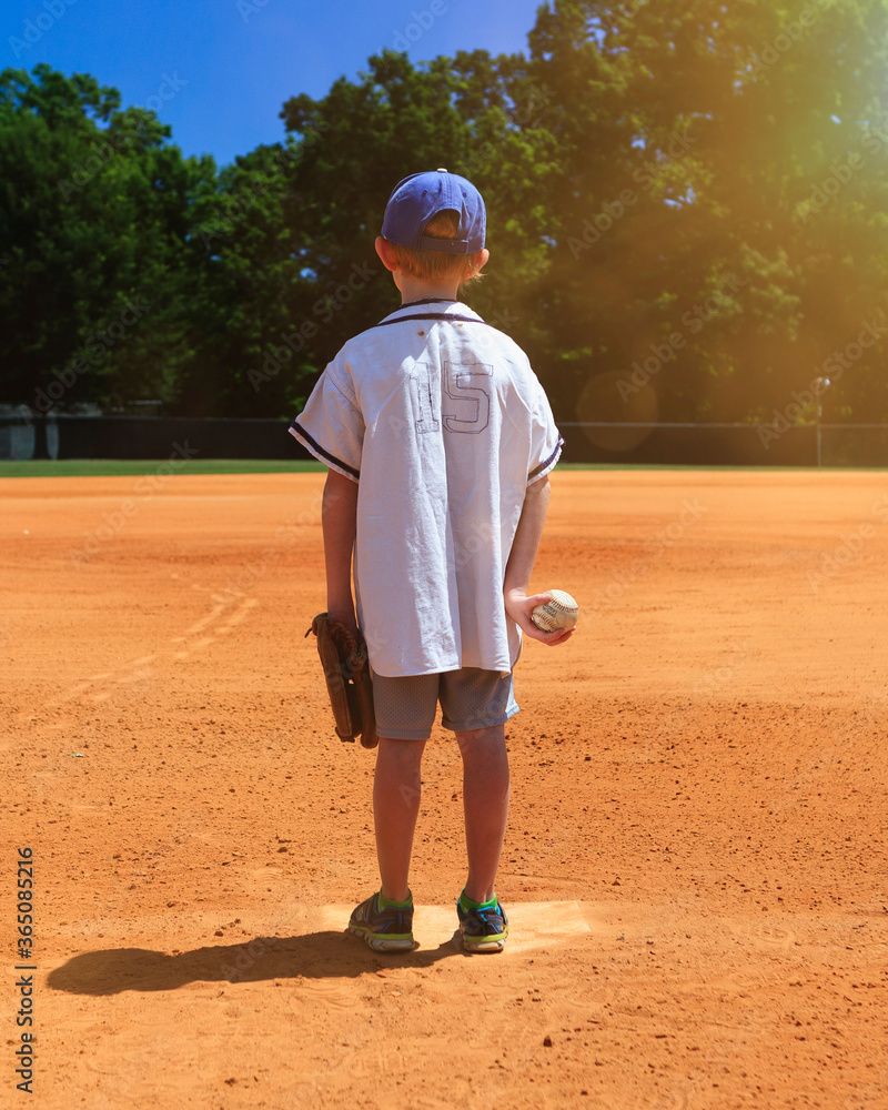 Little boy getting ready to play baseball on a diamond Little boy getting ready to play baseball on a diamond