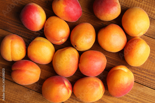 Ripe apricots on a brown wooden table. View from above. Closeup photo