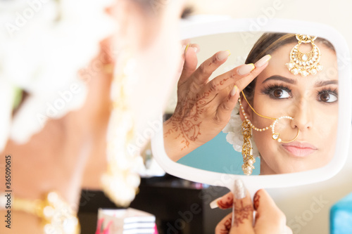 Obraz na plátně Beautiful female model wearing traditional Sikh wedding attire as she prepares f