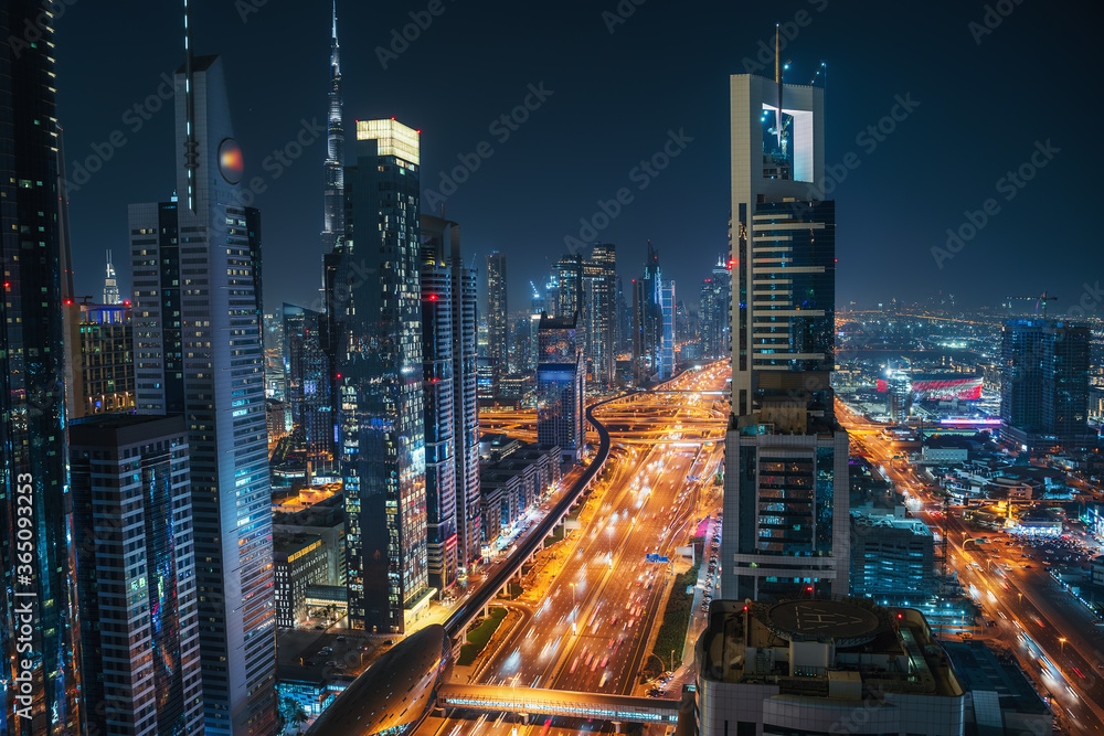 Dubai skyline at night, urban skyscrapers and car traffic, view from above, United Arab Emirates. Dubai skyline at night, urban skyscrapers and car traffic, view from above, United Arab Emirates.
