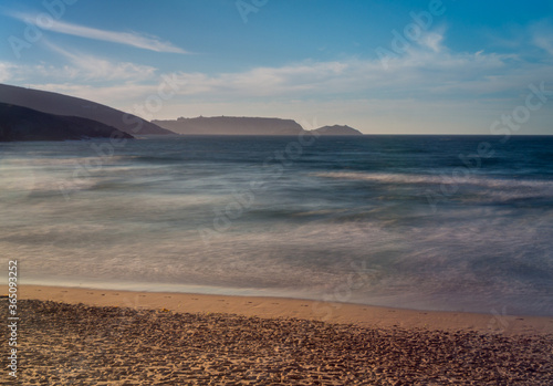 Beaches with waves and cliff at sunset on the Spanish coast