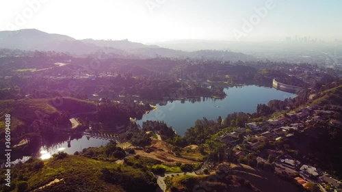 Stunning vast aerial shot over the Holly Reservoir with a hazy LA Downtown in the backdrop.