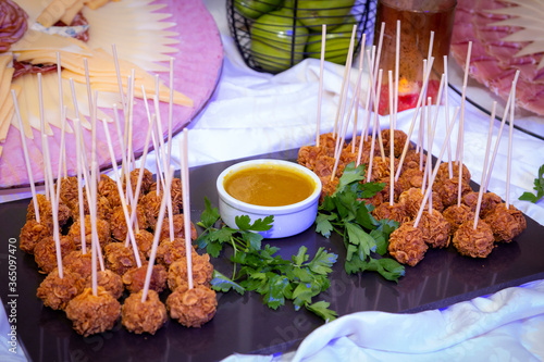 
meatballs overflowing with cereal and cream on frua buffet table decorated with parsley photo