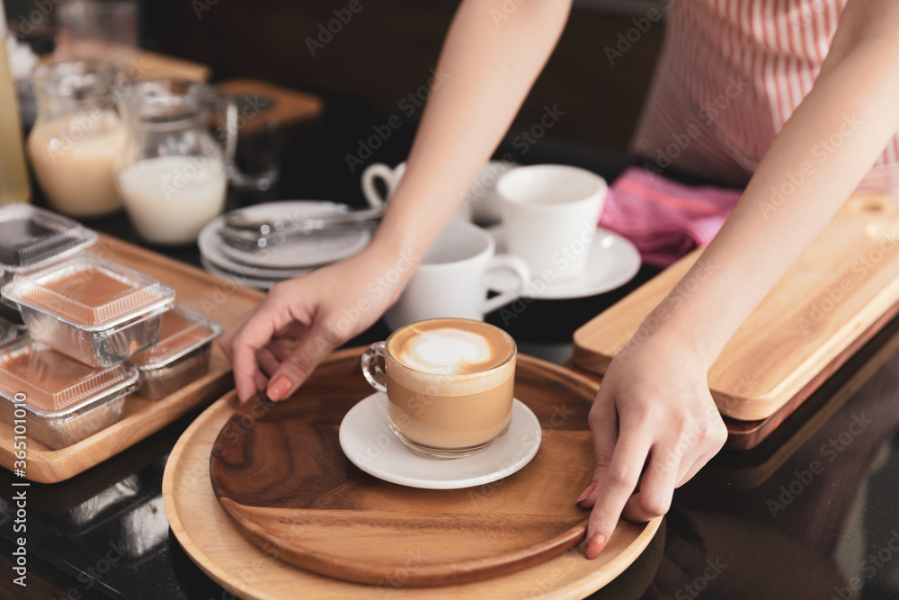Young woman barista standing at coffee shop holding cup serving order fresh hot latte at coffee shop. Young woman barista standing at coffee shop holding cup serving order fresh hot latte at coffee shop.
