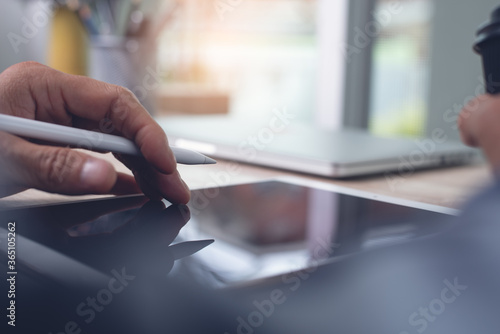 close up of man designer using digital tablet working from home