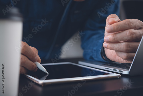man graphic designer using stylus pen touching or drawing on digital tablet