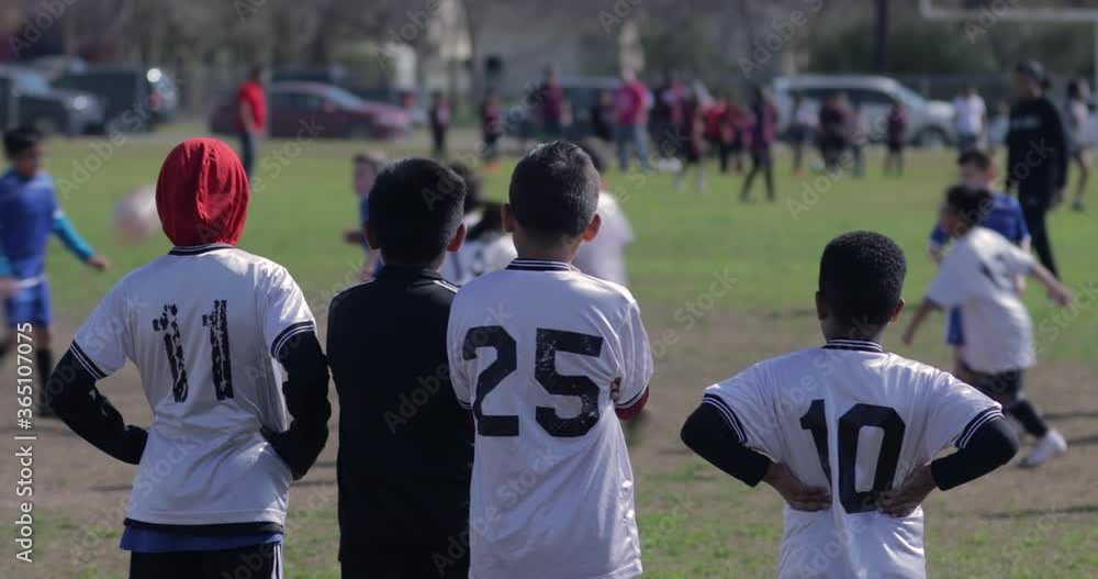 Hispanic boys watching soccer game from the side line in a low income neighborhood Hispanic boys watching soccer game from the side line in a low income neighborhood