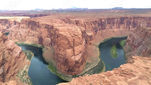 World famous tourists attraction - Horseshoe bend on a cloudy day. Cinematic American Wild West wilderness nature. Aerial red canyon and Colorado river. USA travel and road trip concept footage