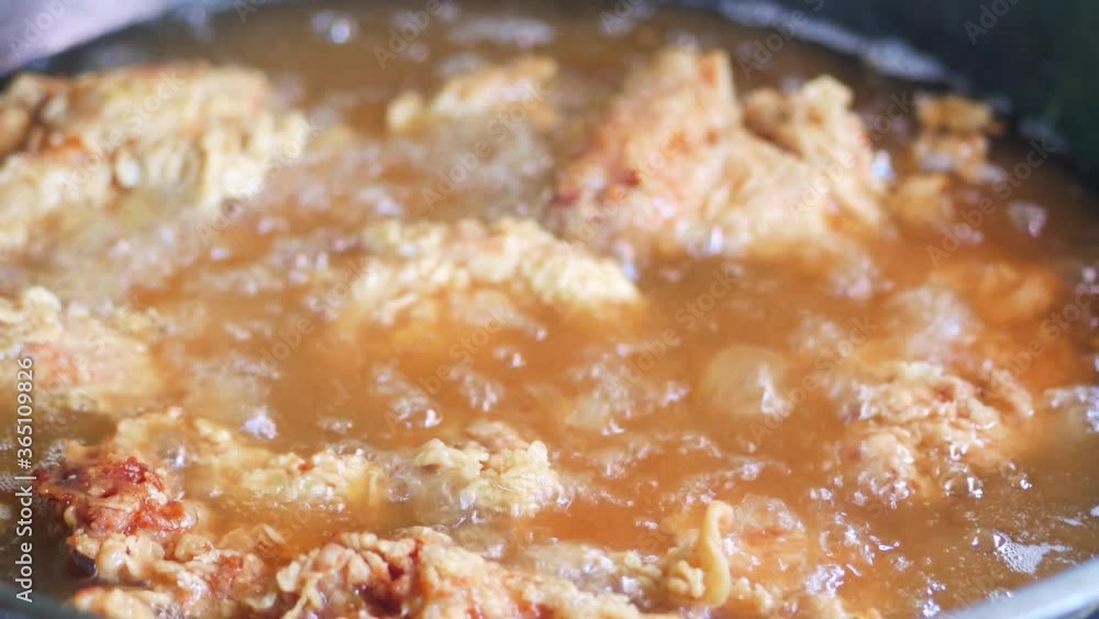 frying chicken in boiling hot oil frying chicken in boiling hot oil
