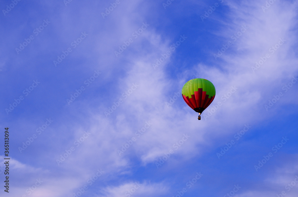 Naklejka premium one balloon of red green in the pink blue sky flies away into the distance