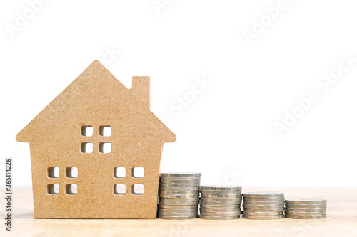 House model and stack of coins on table