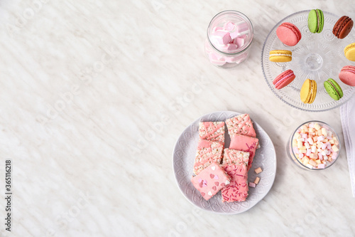 Plate with crispy rice bars and sweets on white background