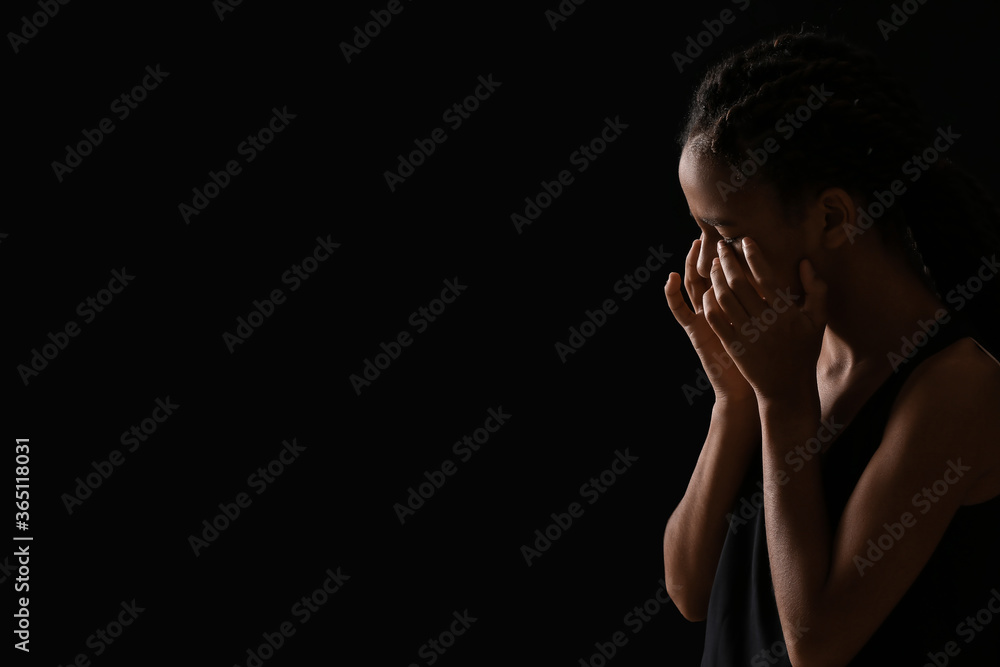 Sad African-American girl on dark background. Stop racism Sad African-American girl on dark background. Stop racism