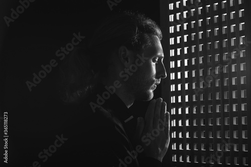 Male priest in confession booth photo