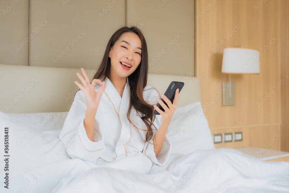Portrait beautiful young asian woman with smart mobile phone in bedroom Portrait beautiful young asian woman with smart mobile phone in bedroom