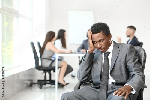 Lonely African-American businessman in office. Stop racism