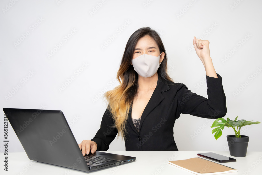An Asian businesswoman wears a surgical mask in an office that works to protect the corona virus. An Asian businesswoman wears a surgical mask in an office that works to protect the corona virus.