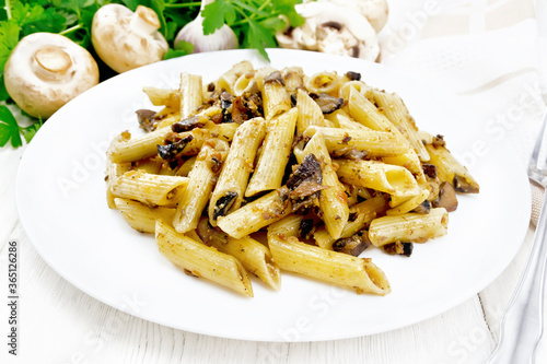 Pasta with mushrooms in white plate on board