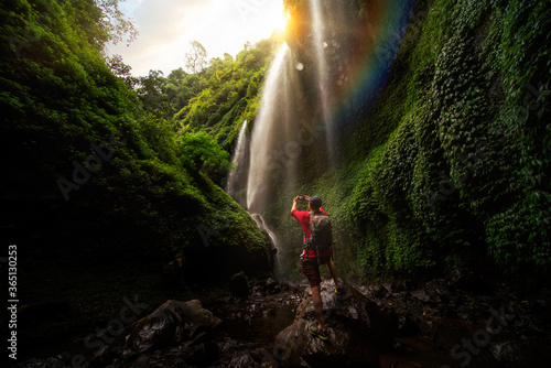 Asian traveller take photo in Madakaripura Water fall, indonesia..