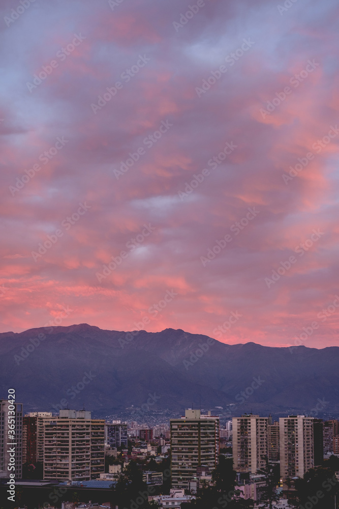 Amazing purple cloudy sunset sky over Santiago downtown and Los Andes mountains, Chile