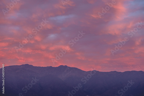 Panorama of amazing purple cloudy sunset sky over Los Andes mountains