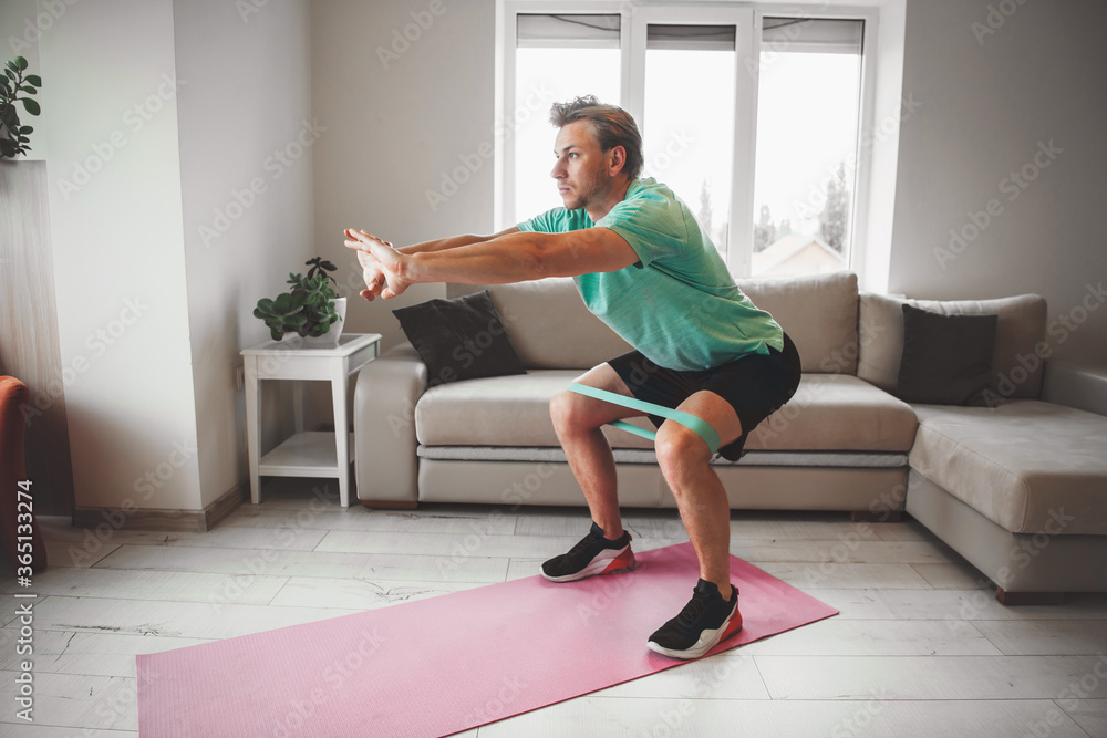 Caucasian man stretching and warming up at home while doing fitness Caucasian man stretching and warming up at home while doing fitness