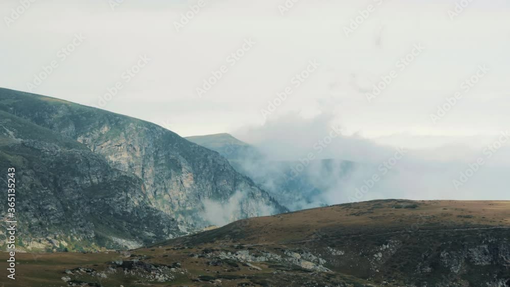 Peaks covered by low clouds near the meadow where the ritual dance paneurhythmy is played. Located near the Rila Lakes in the Rila Mountains, Bulgaria. Peaks covered by low clouds near the meadow where the ritual dance paneurhythmy is played. Located near the Rila Lakes in the Rila Mountains, Bulgaria.