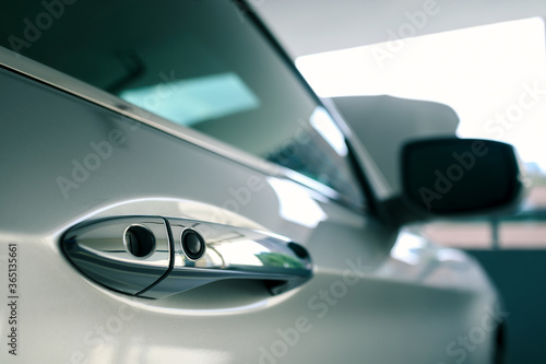 door handle of modern car parked at parking lot of condominium with bonnet or hood open, ready to be checked or fixed, push button to lock vehicle, keyless entry door handle, selective focus © happycreator