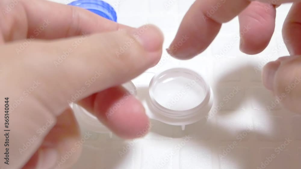 ソフトコンタクトレンズを指に乗せる。コンタクトレンズを装着しようとする様子。